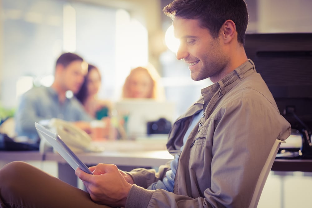Smiling young man using digital tablet in the office Smiling young man using digital tablet in the office